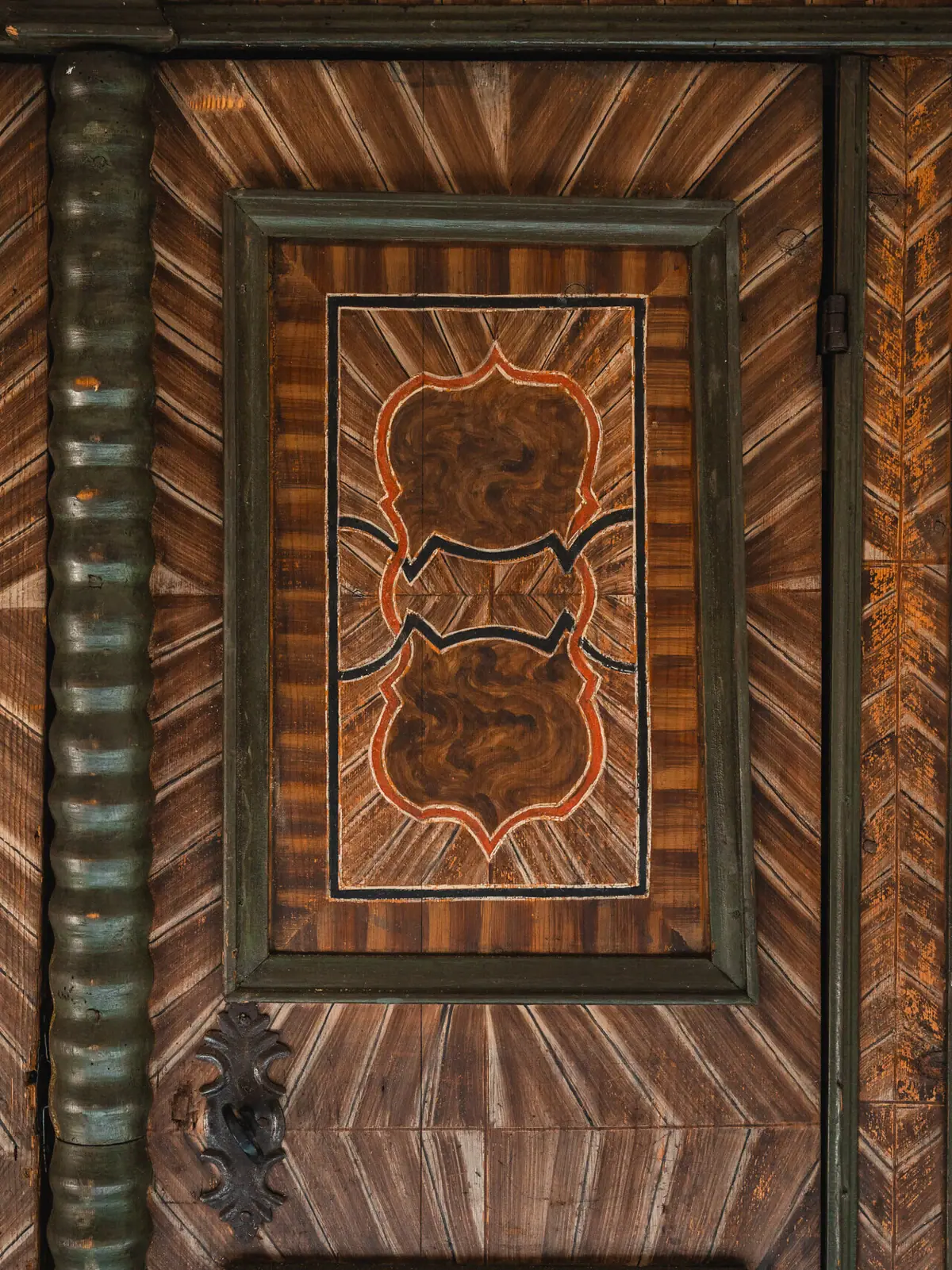 Holztür mit kunstvollem Design und symmetrischen Mustern.