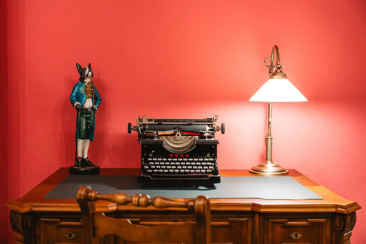 Ein Schreibtisch mit einer Lampe und einer Schreibmaschine.