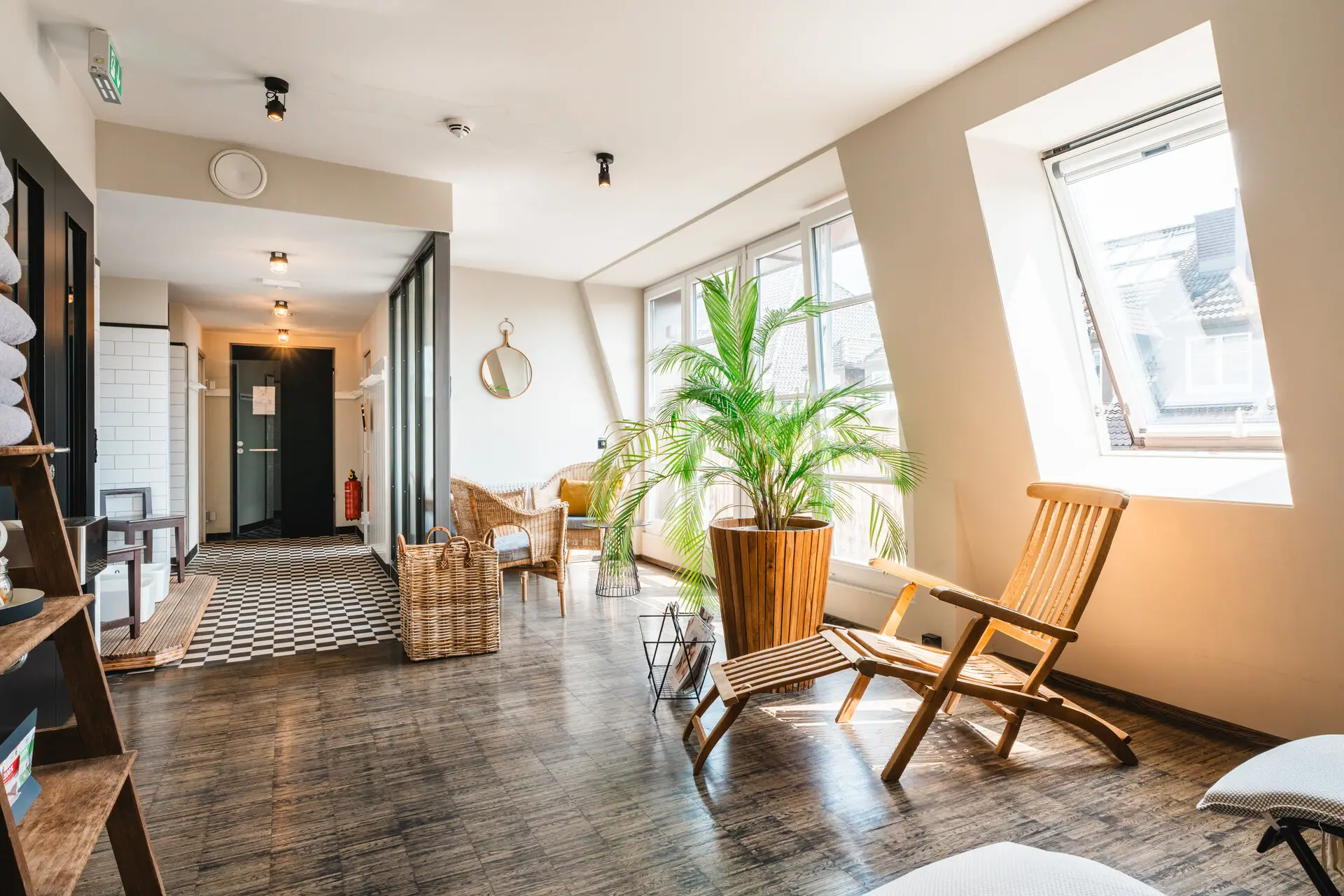 Ontspanningsruimte met ligstoelen Een kamer met ligstoelen en een plant.